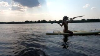 Naked Girl swims on sup board